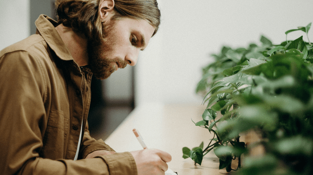 Man writing goals on paper